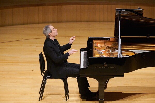피오트르 안데스셰프스키가 롯데콘서트홀에서 열린 리사이틀에서 연주하고 있다. 오케스트라 단원들이 앉는 의자 두개를 겹쳐 앉은 모습이 인상적이다. ⓒ인아츠프로덕션 제공