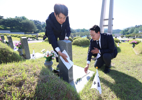 5월 15일 오전 광주 북구 국립 5·18 민주묘지에서 이준석 당시 개혁신당 대표와 당선인들이 5·18 묘지에 헌화·참배하고 묘비를 닦고 있다. 사진=연합뉴스