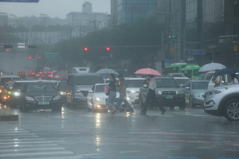  비가 내리는 13일 서울 서초구 이수역 사거리에서 시민들이 우산을 쓰고 횡단보도를 걸어가고 있다. 2023.7.13 ⓒ연합뉴스